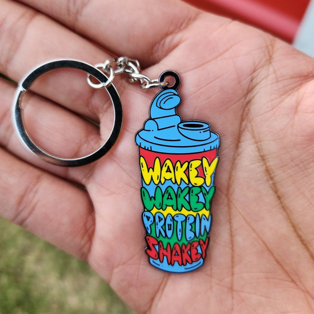 Enamel Keychain with "WAKEY WAKEY PROTEIN SHAKEY" text