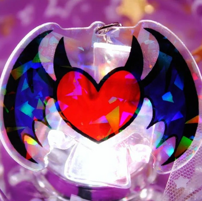 A heart shaped acrylic charm with stars and hearts on it.