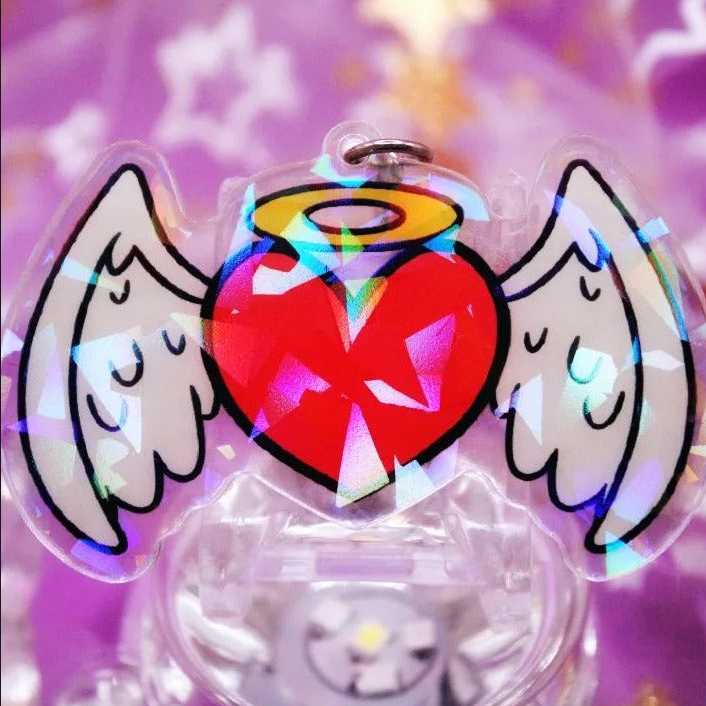 A heart shaped acrylic charm with stars and hearts on it.